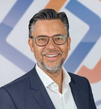 Dr. Markus Landrock, Managing Director Epay DACH, präsentiert sich in einem professionellen Umfeld. Sein Lächeln und die formelle Kleidung unterstreichen die positive Partnerschaft zwischen Epay und dem Flughafen München im Bereich innovativer Zahlungslösungen.