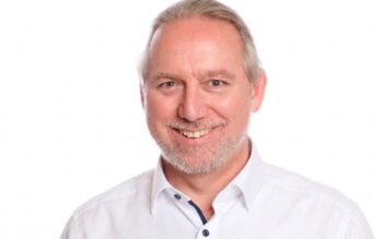 Michael Baldauf, Financial Services Senior Director bei Pegasystems, lächelt im weißen Hemd vor hellem Hintergrund; seine Bankerfahrung umfasst zehn Jahre Transformation in einer Genossenschaftsbankengruppe und unterstützt den Umgang mit BaFin-KI-Pflichten.