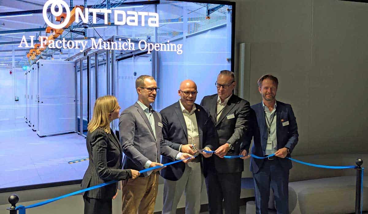 Die Eröffnungszeremonie der AI Factory von NTT Data in München zeigt mehrere Personen, die ein blaues Band durchschneiden. Im Hintergrund sind Serverräume sichtbar, die für den Betrieb der Künstlichen Intelligenz vorbereitet sind.