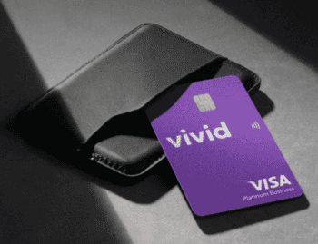 Eine violette Vivid Visa Platinum Business-Karte steckt halb in einem schwarzen Kartenetui; sie steht für Firmenkarten im integrierten Ausgabenmanagement für KMU.